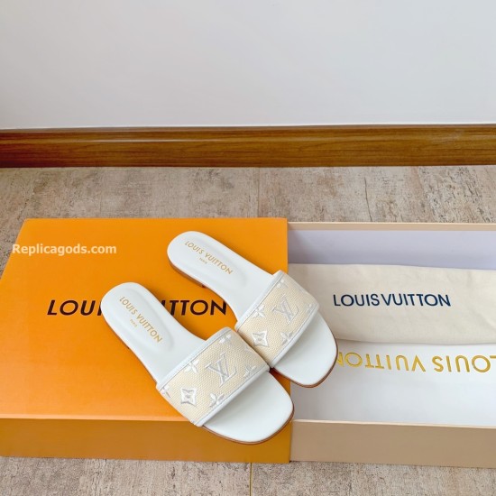 L Revival Flat Mules in white - Angled Presentation View Angled layout of L Revival Flat Mules in white resting on a signature orange presentation box