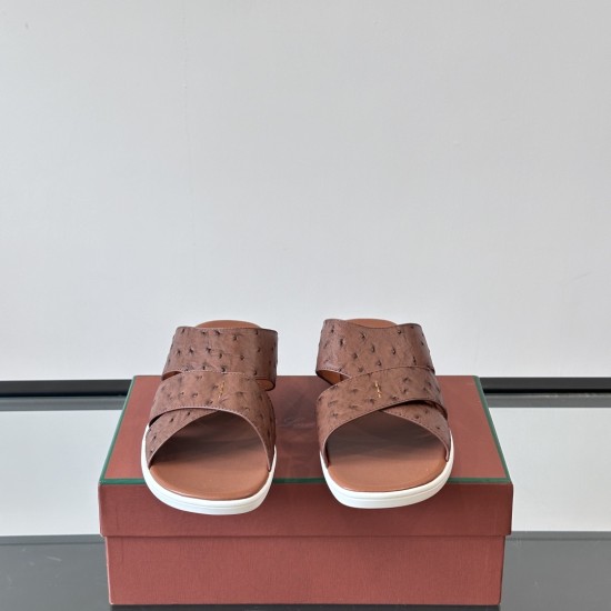 Frontal view of Loro Piana tabac brown ostrich leather slide sandals showcasing the criss-cross strap design