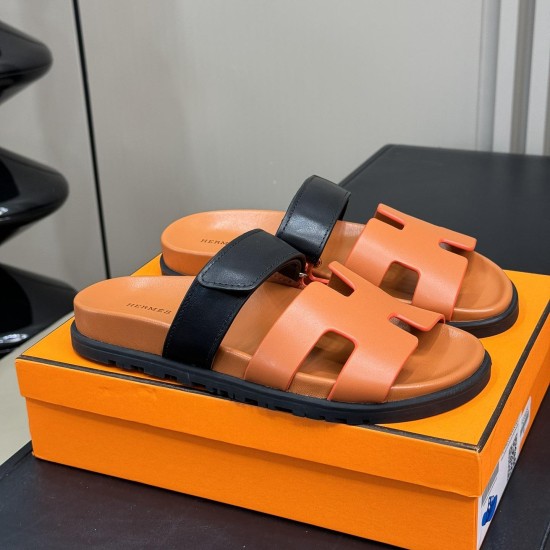 Hermes brown and black sandals angled display Angled perspective of Hermes brown and black sandals presented on top of their packaging box
