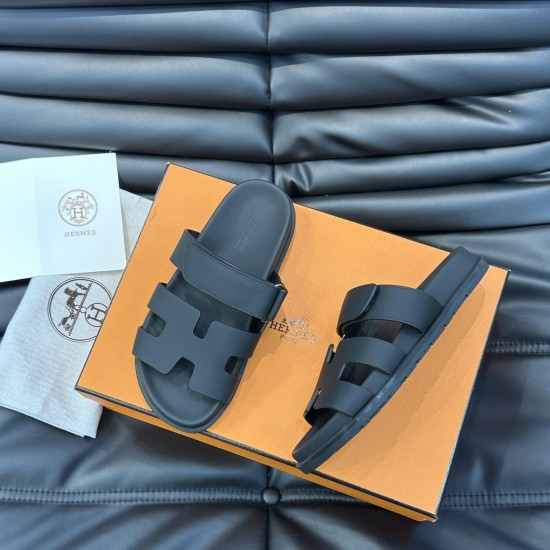 Hermes Chypre black leather sandals box view Angle view of Hermes Chypre black leather sandals resting on orange packaging box