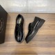 Angled view of black Prada Men's Brushed Leather Derby Brogue Shoes Angled top-down view of black Prada Men's Brushed Leather Derby Brogue Shoes beside a shoebox