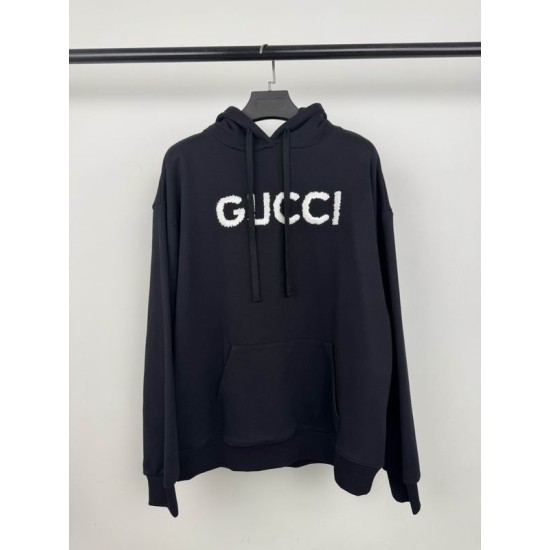 Front view of black Gucci cotton hoodie with white boucle logo applique and kangaroo pocket on a hanger