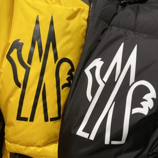 Detailed view of Moncler Men's chest logo prints on yellow and black fabrics