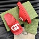 Gucci Red Slide Sandals Angled Display in red and white Angled top view of Gucci red slide sandals resting on a patterned green box in red and white
