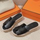 Hermes Eze Black Platform Sandals Pair Front View Front three-quarter angle of the pair of black sandals resting beside orange brand boxes