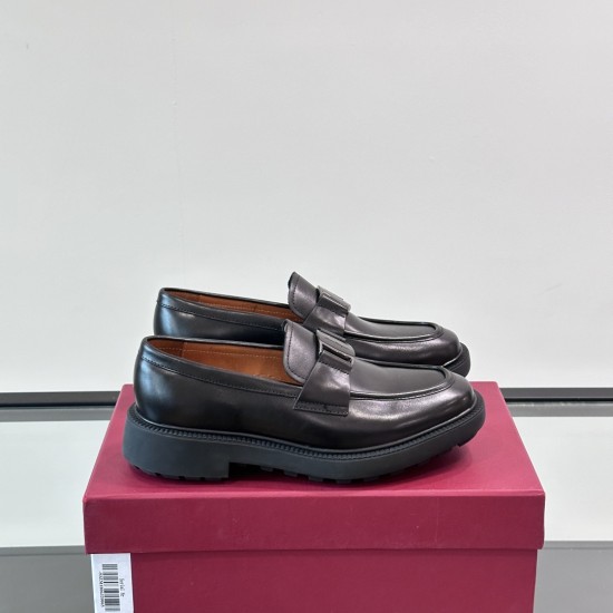 Pair of Ferragamo Men's Black Leather Chunky Sole Loafers resting on a burgundy shoe box seen from the side.
