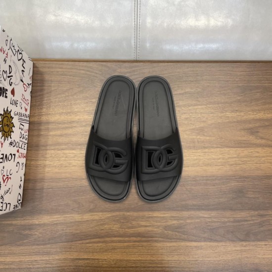 Direct overhead view of both Dolce & Gabbana black rubber slides displaying embossed logo straps