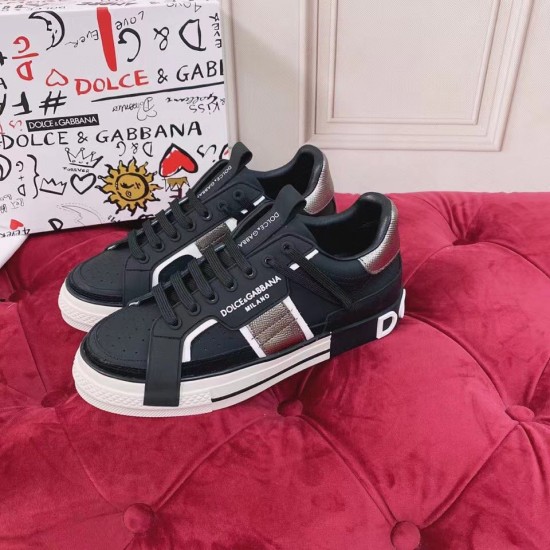 Dolce & Gabbana Custom 2.Zero Elevated View in black and white Angled view of black leather trainers on a plush surface next to branded box in black and white