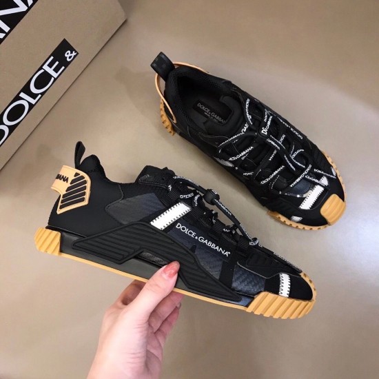 Top down view showing pair of Dolce & Gabbana black trainers next to box in black and tan