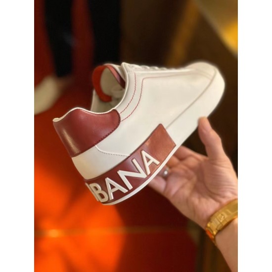 Close-up handheld angle of the branded red heel band on Dolce & Gabbana trainer in white and red
