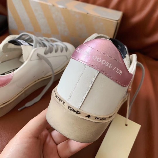 Back view of Golden Goose trainer showing metallic pink heel patch and thick sole in white and silver