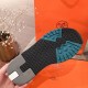Bottom outsole view of the Hermes grey trainer featuring black and teal tread details