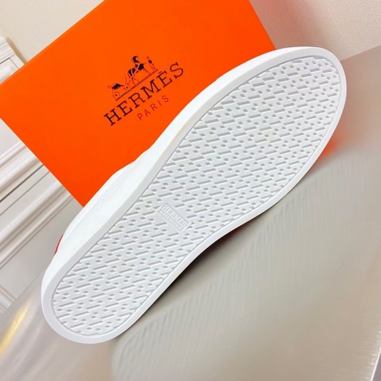 Underside tread pattern of the white rubber sole on Hermès low top trainer in white and orange
