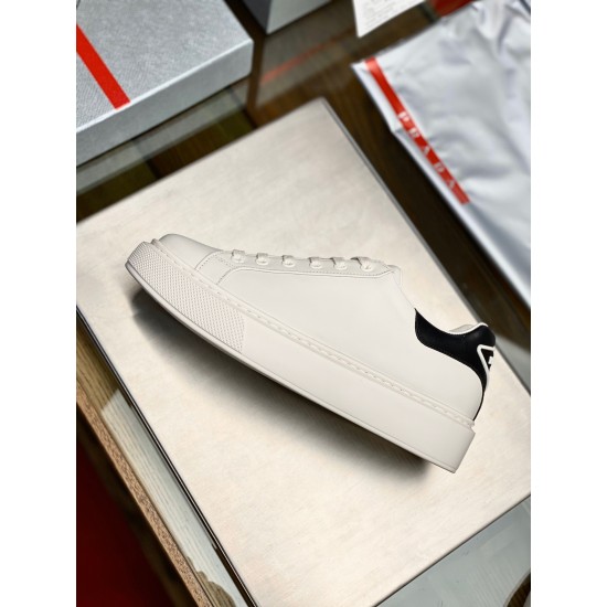 Lateral side view of single Prada Macro white leather trainer on display tray in white and black