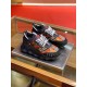 Pair of Versace black and red baroque print trainers displayed on a metal tray in black and gold