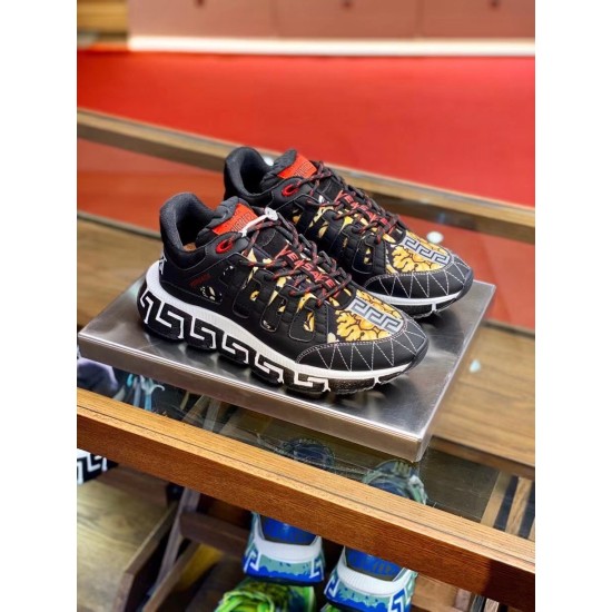 Versace Trigreca Black Trainers Pair View in black and yellow Three-quarter pair view of black and yellow Barocco Trigreca trainers displayed on glass shelf