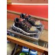 Versace Trigreca Black Trainers Pair View in black and yellow Three-quarter pair view of black and yellow Barocco Trigreca trainers displayed on glass shelf