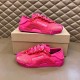 Two Dolce & Gabbana fuchsia pink lace trainers presented on and beside a box