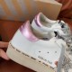Close-up of Golden Goose metallic pink heel tab and handwritten sole text detail in white and silver