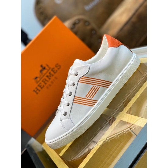 Three-Quarter View of White and Orange Trainer Three-quarter side angle of white leather trainer resting on a glass surface in white and orange