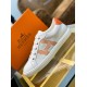 Three-Quarter View of White and Orange Trainer Three-quarter side angle of white leather trainer resting on a glass surface in white and orange