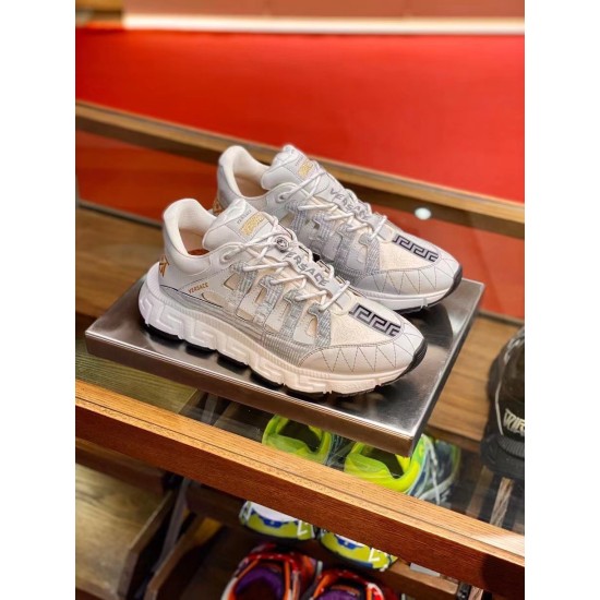 Versace Trigreca Low Top White Trainers Display View in white and gold Three-quarter front view of Versace Trigreca Low Top White Trainers on glass shelf in white and gold