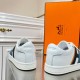 Rear view showing white leather heels of Hermes Boomerang trainers in white and blue