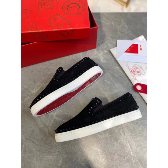 Pair of Christian Louboutin black Pik Boat Flat trainers resting on table beside red shoebox in black and white