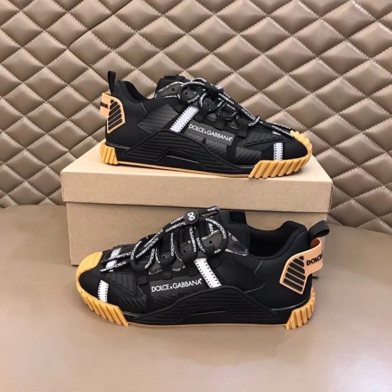 Pair of Dolce & Gabbana black fabric trainers displayed on top of box in black and tan