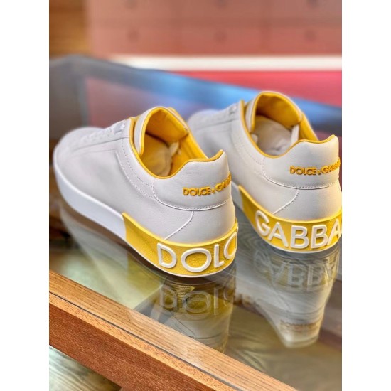 Rear Heel Detail on White and Yellow Trainers Rear angle view detailing yellow heel tabs with raised white logo lettering