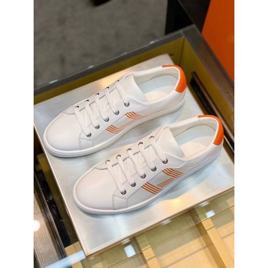 Top View Pair of White and Orange Leather Trainers Top-down view of both white leather trainers with orange accents placed side by side