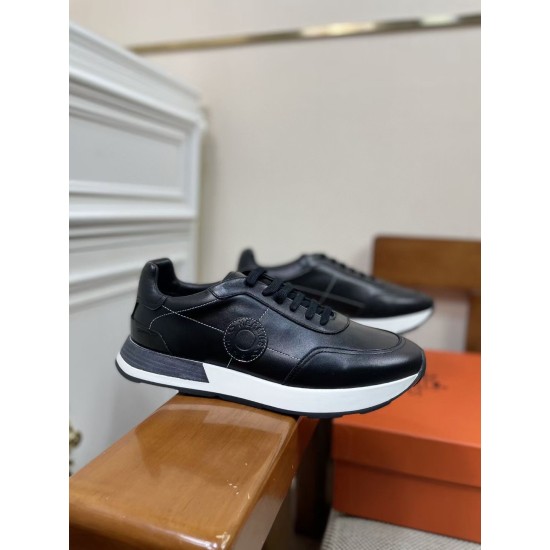 Hermes Drive Leather Low Top Trainers Black Angle View in black and white Perspective view of Hermes Drive Leather Low Top Trainer Black resting on wooden armrest in black and white