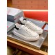 Angled front-side view of a pair of Prada Macro white and black leather trainers