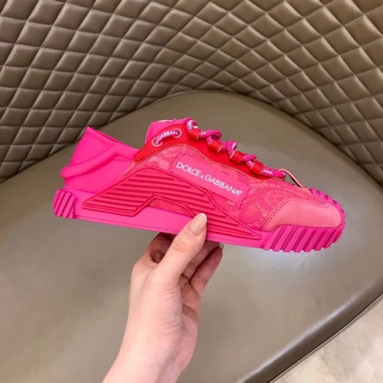 Hand holding a Dolce & Gabbana fuchsia pink lace trainer showing lateral side logo details
