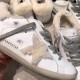 Golden Goose Super-Star Shearling Star Detail in white and grey Close-up detail of shearling star appliqué and GGDB/SSTAR gold lettering on white leather in white and grey