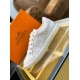 Hermes Avantage white trainer displayed with orange brand shoe box