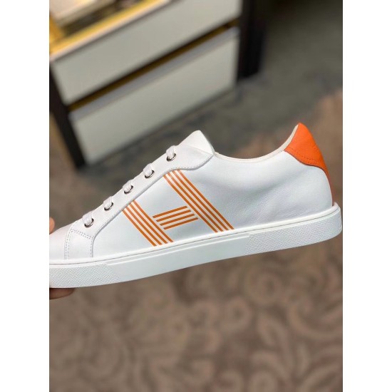 Medial Side View of White Leather Trainer in white and orange Medial side profile view of white leather trainer showing smooth leather and orange heel detail