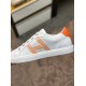 Medial Side View of White Leather Trainer in white and orange Medial side profile view of white leather trainer showing smooth leather and orange heel detail