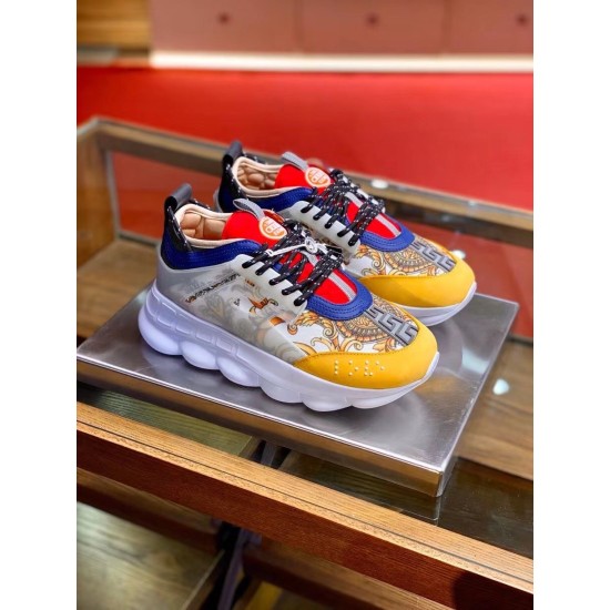 Versace Chain Reaction Baroque Print White Trainers Pair Angle View in white and yellow Pair of Versace Chain Reaction Baroque Print White Trainers displayed on a metallic pedestal in white and yellow
