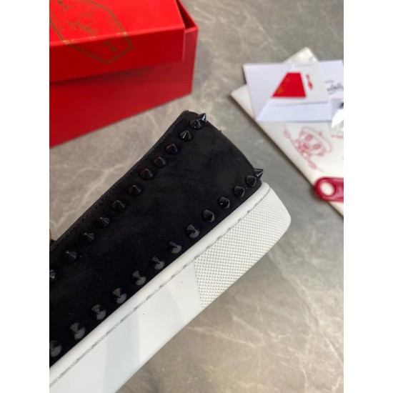 Close-up view of black spike trim and white rubber sole on Christian Louboutin suede trainer