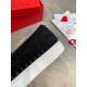 Close-up view of black spike trim and white rubber sole on Christian Louboutin suede trainer