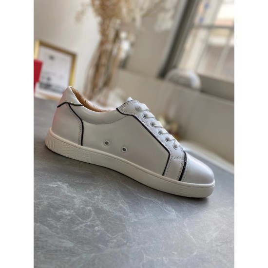 Lateral side view of a single Christian Louboutin Vieirissima white leather trainer resting on grey marble surface in white and black