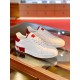 Pair of Dolce & Gabbana white and red Portofino trainers displayed on glass table