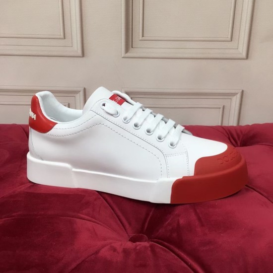 Side profile of a white leather trainer with thick white sole and red toe cap