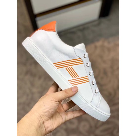 Lateral Side View of White and Orange Leather Trainer Side profile view of white leather trainer held showing graphic orange side stripes
