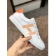 Lateral Side View of White and Orange Leather Trainer Side profile view of white leather trainer held showing graphic orange side stripes