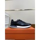 Hermes Drive Leather Low Top Trainers Black Lateral Profile in black and white Lateral side view of single Hermes Drive Leather Low Top Trainer Black resting on orange box in black and white