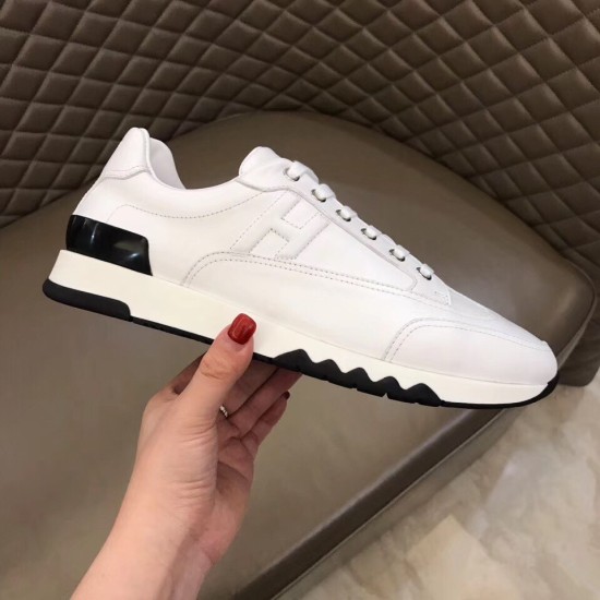 Trail Leather Trainer Side Detail in white and black Handheld view highlighting the side silhouette and black contrast heel accent of the white leather trainer.