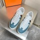 Top-down view of Hermes Boomerang white and blue leather trainers pair
