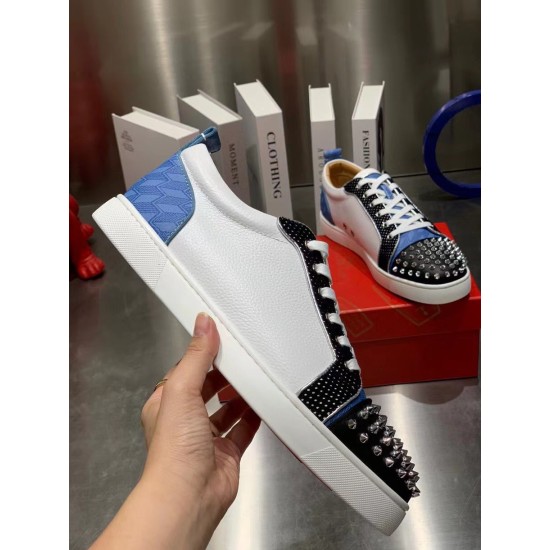 Christian Louboutin Louis Junior Spikes Orlato Handheld View in white and blue Hand holding a white Christian Louboutin Louis Junior Spikes Orlato trainer showing lateral leather panel and spike detail in white and blue